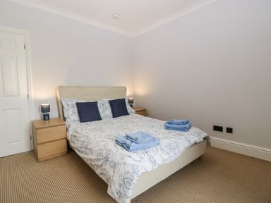 A bedroom with a double bed flanked by two wooden bedside tables with lamps at Moors Farm Littledean