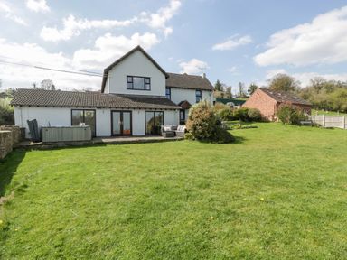 A house with a large backyard and patio furniture at Moors Farm in Littledean