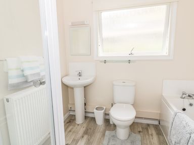 A bathroom with a toilet sink bathtub and window at Middle Hivron in Bleddfa