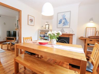 A dining room with a table and chairs at Driftwood Cottage Heacham