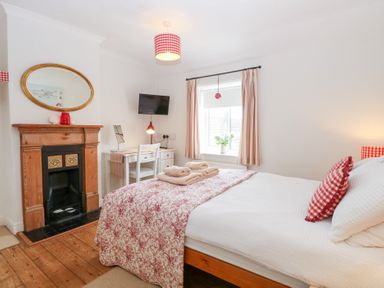 A bedroom with a bed and desk at Driftwood Cottage in Heacham