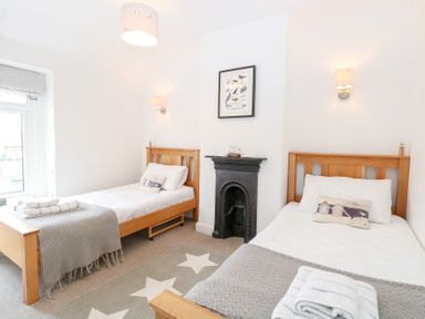 A bedroom with two single beds and a fireplace at Driftwood Cottage Heacham