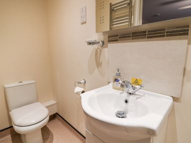 A small bathroom with a toilet and a sink with soap dispenser at Caban Nant Ddu in Rhayader