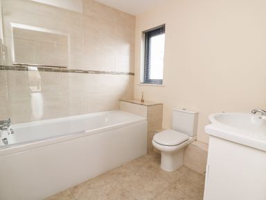 A bathroom with a bathtub toilet sink and window at Caban Nant Ddu in Rhayader
