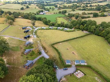 An aerial view of cabins and fields at Caban Nant Ddu in Rhayader