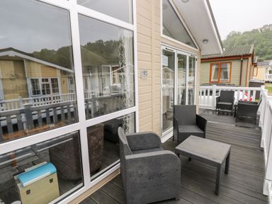 A deck with outdoor chairs and a table at 95 The Haven Wisemans Bridge near Saundersfoot