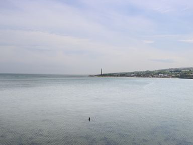 A coastal view with calm sea water and buildings along the shoreline at Iona 10 Palace Street East in Berwick-upon-Tweed
