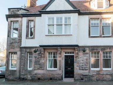 The front exterior of a house with stone and white walls black door and multiple windows at Iona 10 Palace Street East in Berwick-upon-Tweed