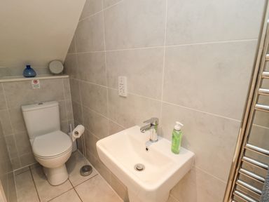 A bathroom with a toilet sink and towel rack at Iona 10 Palace Street East Berwick-upon-Tweed