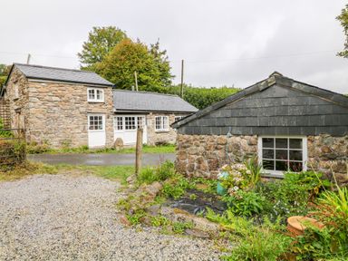 Stone buildings with slate roofs surrounded by plants and gravel at Treverbyn Smithy in St Neot