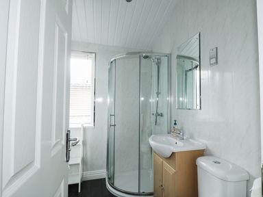 A bathroom with shower enclosure sink with cabinet toilet and window at 22 Thirlmere in Troutbeck Bridge