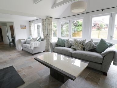 A living room with two grey sofas and a marble coffee table near large windows at Pebworth Cottage in Pebworth near Stratford-upon-Avon