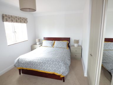 A bedroom with a double bed two bedside tables with lamps a window with a blind and a mirrored wardrobe door at Pebworth Cottage Pebworth near Stratford-upon-Avon