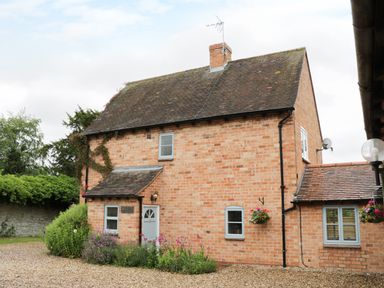 Exterior of a two story brick house with a small porch and garden at Pebworth Cottage Pebworth near Stratford-upon-Avon