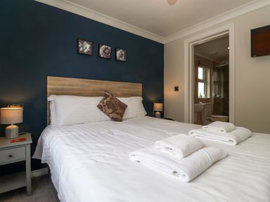 A bedroom with a double bed and folded towels on the bed at Claife View Lodge in Troutbeck Bridge
