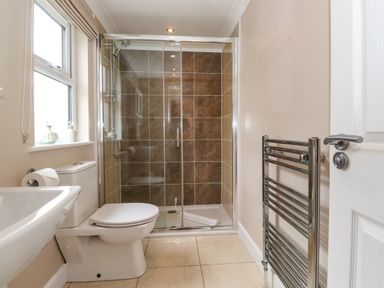 A bathroom with a toilet sink shower and towel rack at Claife View Lodge in Troutbeck Bridge
