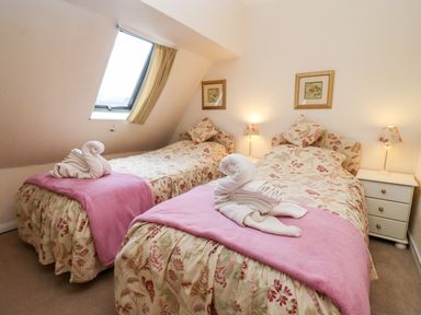 A bedroom with two single beds and a window at Rosemary Cottage in Bourton-on-the-Water