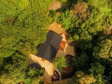 An aerial view of a building surrounded by dense trees and landscaping at Wilderness Lodge in Stiperstones
