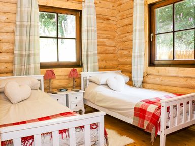 A bedroom with two single beds and a nightstand between them at Wilderness Lodge in Stiperstones