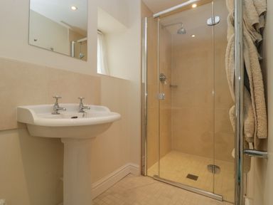 A bathroom with a pedestal sink and glass shower enclosure at Drover's in Sutton Mallet