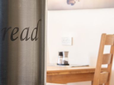 A metal container with the word read on it with a wooden chair and table in the background at Buttermere in Sawrey near Hawkeshead