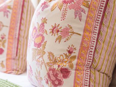 A close up of two cushions with floral and striped patterns
