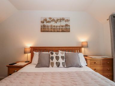 A bedroom with a bed and decorative pillows at Wold Cottage in Hunmanby