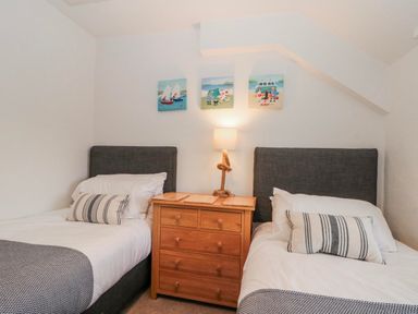 A bedroom with two single beds and a nightstand at Wold Cottage in Hunmanby