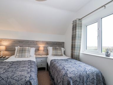 A bedroom with two single beds and a window at Wold Cottage in Hunmanby