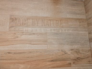 A close-up of wooden-style flooring with text at Wold Cottage in Hunmanby