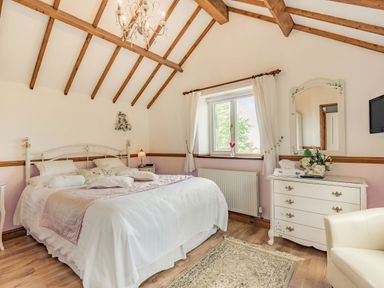 A bedroom with a bed a window a chest of drawers and a chair at Y Becws in Llanbedr near Harlech