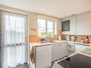 A kitchen with a dishwasher sink microwave kettle and stove at Harvest Moon in Grundisburgh