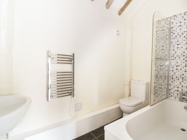 A bathroom with a bathtub shower toilet sink and heated towel rail at Jackos Barn in Homersfield