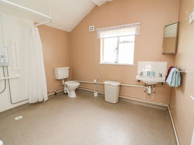 A bathroom with a toilet sink shower and window at Green Cottage in Pant-y-Dwr near Rhayader
