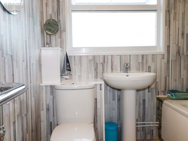 A bathroom with a toilet and sink at Merlin's Retreat in Tintagel