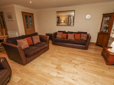 A living room with sofas and a coffee table at Long Cart Cottage in Embleton