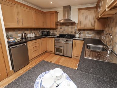 A kitchen with cabinets and appliances at Long Cart Cottage in Embleton