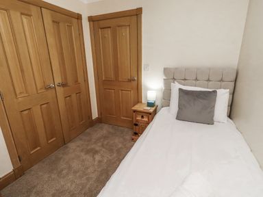 A bedroom with a single bed and a bedside table at Long Cart Cottage Embleton