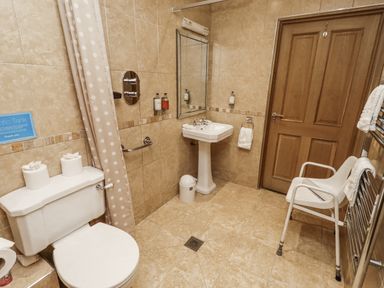 A bathroom with a sink, toilet and shower at Long Cart Cottage in Embleton