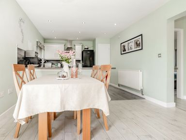 A dining table with chairs and flowers in a kitchen and dining area at Kingfisher Lodge in Brandesburton