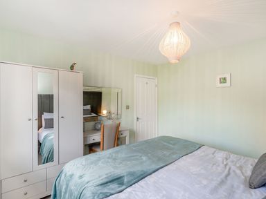 A bedroom with a bed a wardrobe a desk with a chair and a framed picture on the wall at Kingfisher Lodge in Brandesburton