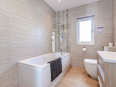 A bathroom with a bathtub shower combo toilet and sink at Kingfisher Lodge in Brandesburton