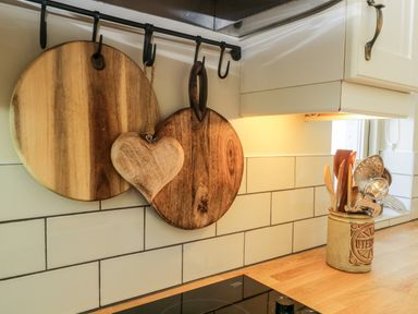 Wooden cutting boards and kitchen utensils in a container on a counter at Gable End in Coniston near Hawkshead