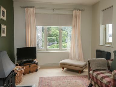 A living room with a television and an ottoman at Gable End in Coniston near Hawkshead