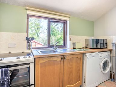A kitchen with a stove a sink a dishwasher a washing machine a microwave and kitchen utensils at Highbury in Spittal near Haverfordwest