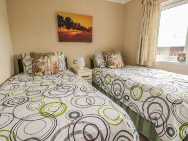 A bedroom with two single beds and a window at Little Gem Lodge in Charlesfield near St Boswells