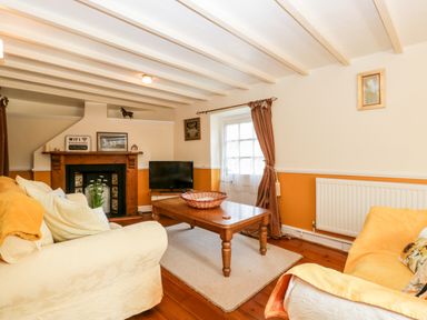 A living room with two sofas a wooden coffee table and a fireplace at The Pound in Trellech near Monmouth