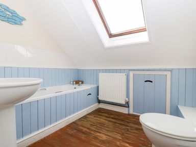 A bathroom with a bathtub sink toilet skylight and wooden floor at The Pound in Trellech near Monmouth