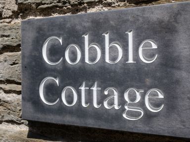 A stone engraved sign with the words Cobble Cottage