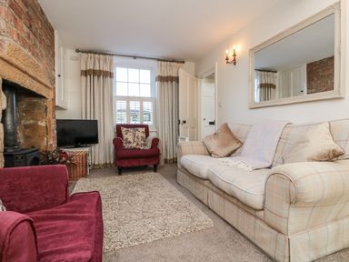 A living room with a sofa and an armchair at Croft View in Fylingthorpe near Robin Hood's Bay